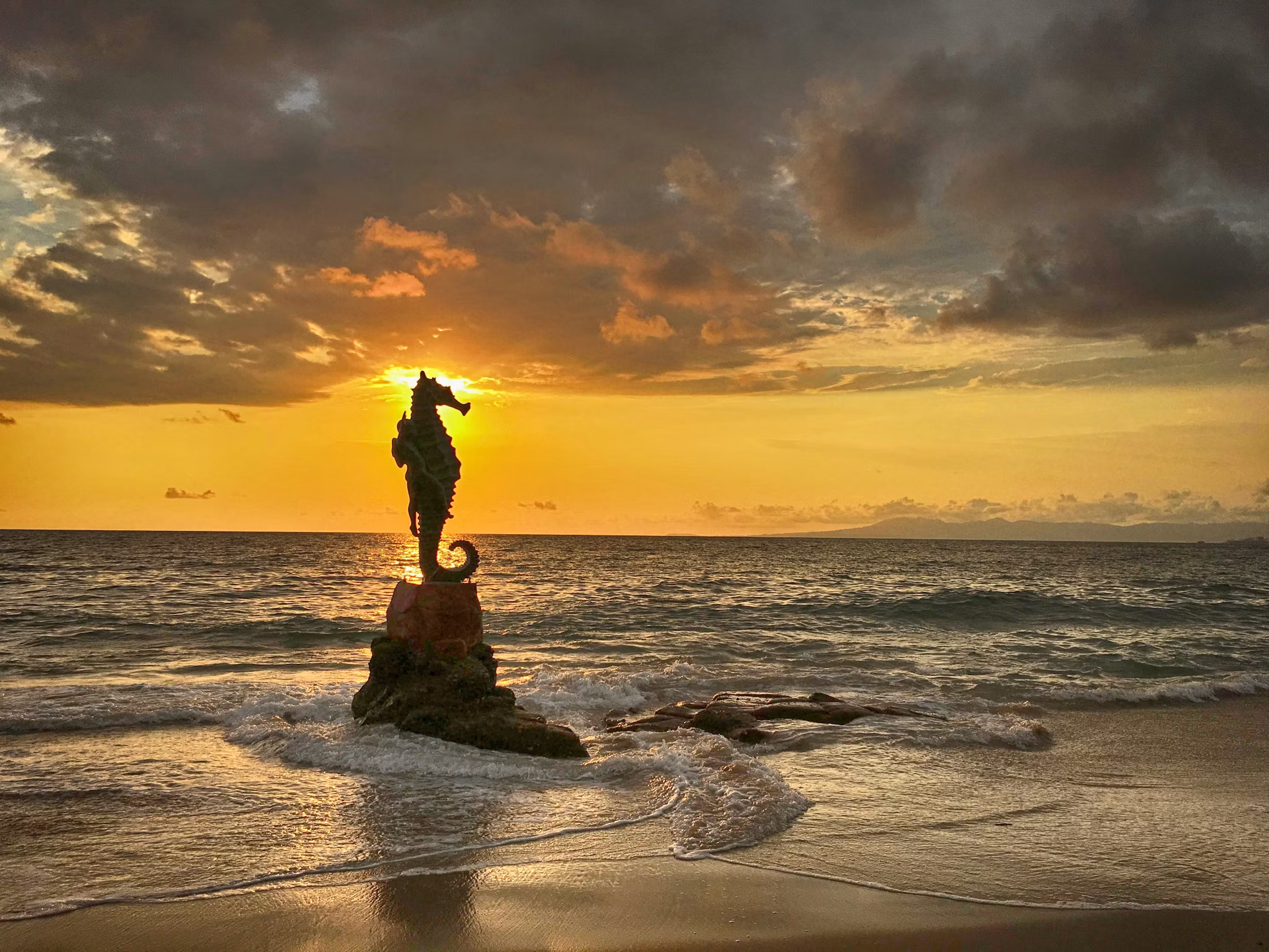 The Boy on the Seahorse sculpture on the Puerto Vallarta shoreline at sunset